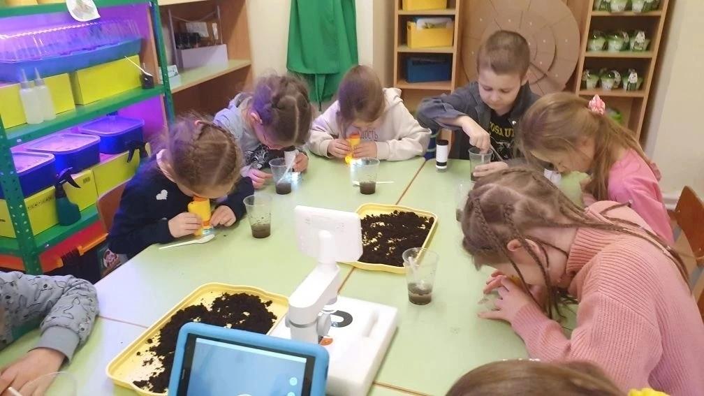 Жети рассматривают в микроскоп каплю воды с растворенной в ней почвой