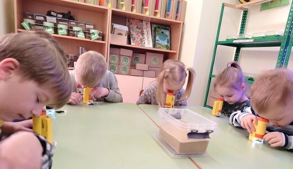 Дети рассматривают песок под микроскопом