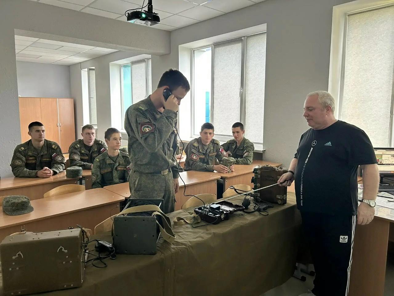 На фото Юрченко Д.В. и кадеты изучают средства связи