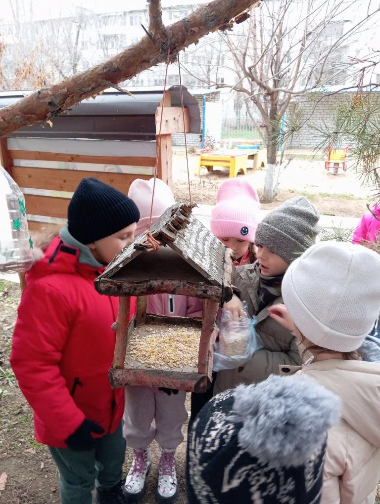 Дети кормят птиц зимой