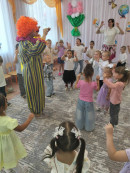 Праздник продолжается! Клоун показывает ребятам забавные фокусы.