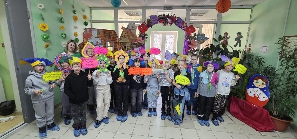 Дети с учителем в холе в маскарадных шапках