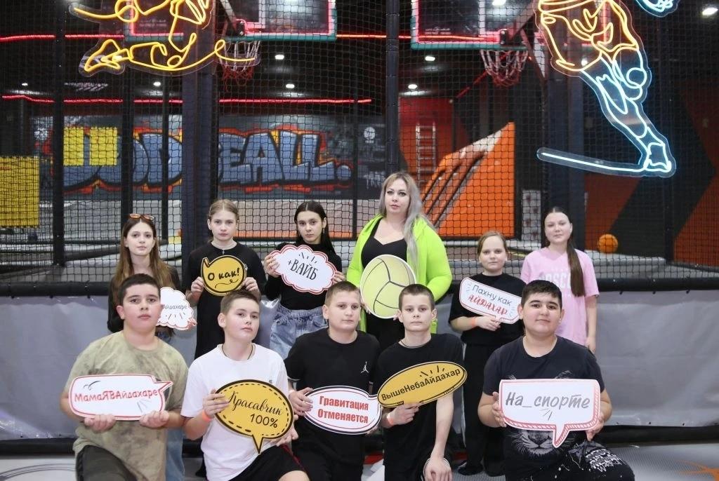 Ребята с учителем держат в руках таблички с надписями