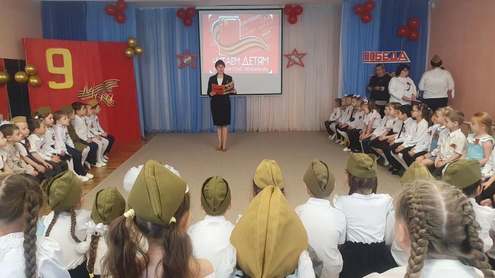 Воспитатель читает детям о войне.