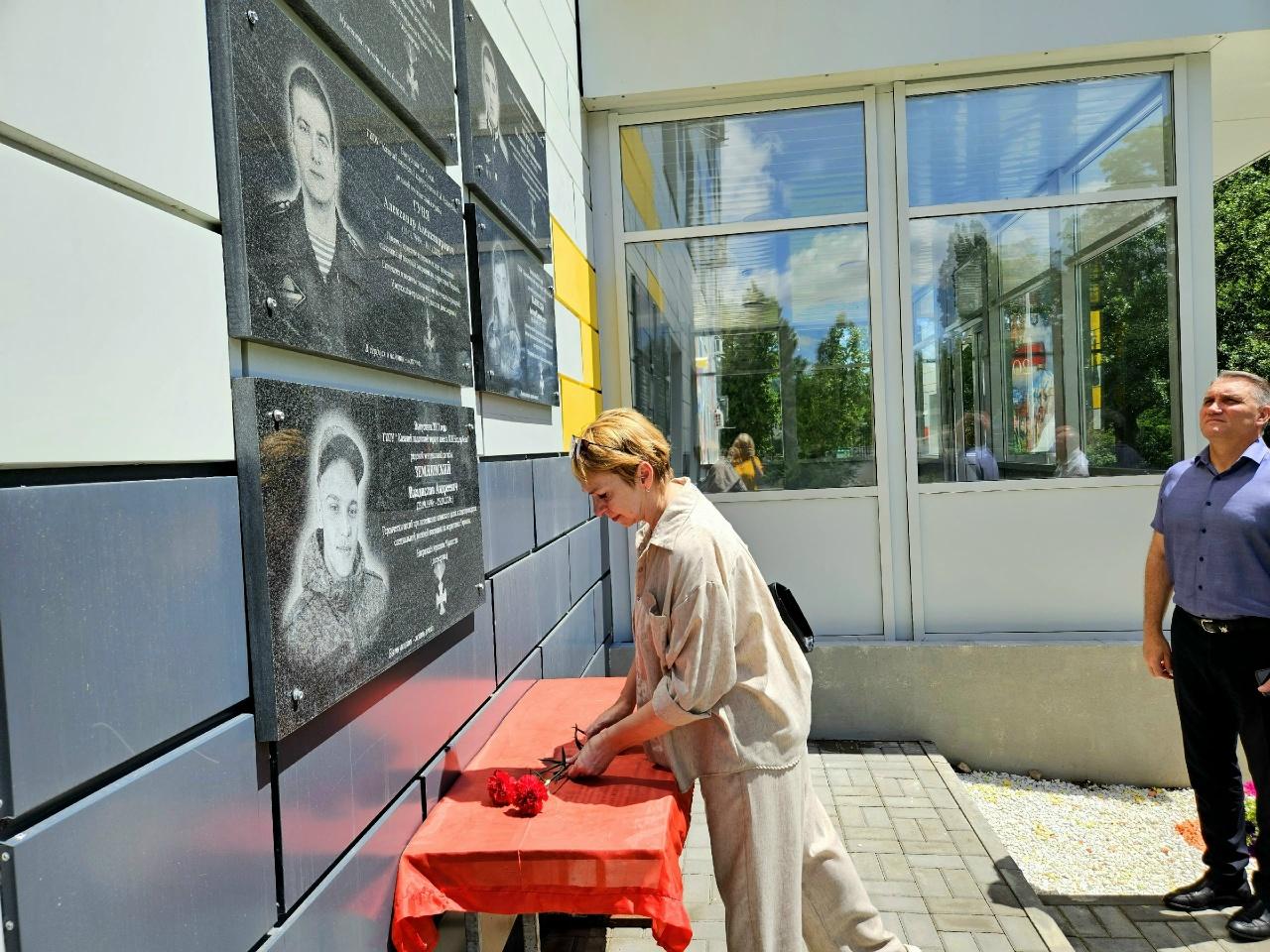 На фото Шевченко О.В. возлагает цветы к памятной доске сына Бирюкова Андрея