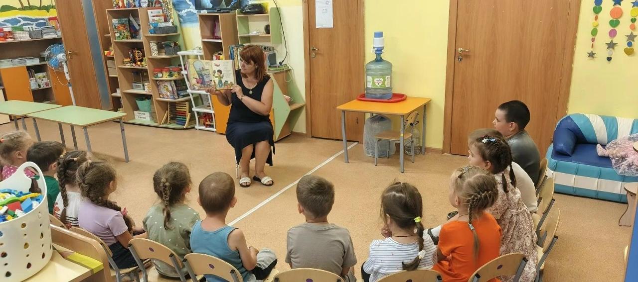 Воспитатель читает детям книгу